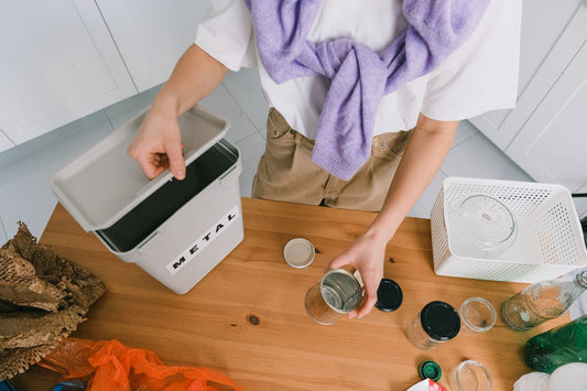 A person preparing to recycle an empty candle jar by separating materials like metal lids and glass containers—demonstrating how to recycle candle jars the right way at home.