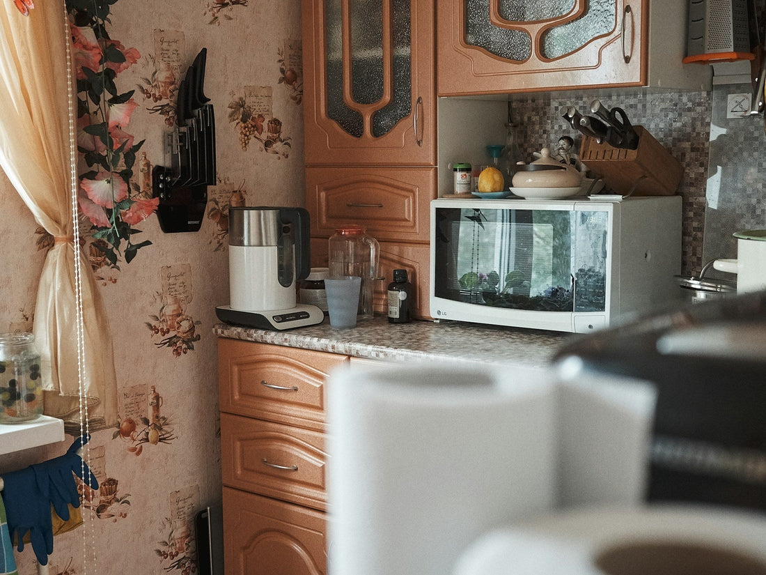 A cozy vintage-style kitchen with a microwave on the countertop—perfect setting for discussing whether you can microwave a candle safely.
