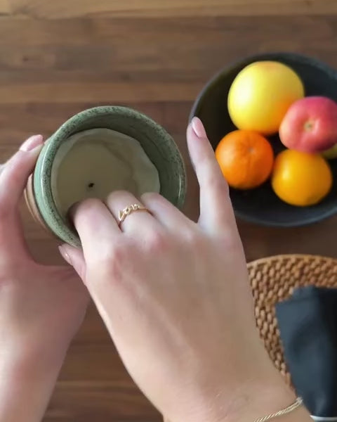 Load video: Hands removing a finished soy wax candle refill and replacing it with a fresh refill inside a reusable ceramic ReCandle Co. vessel, with no scraping or mess