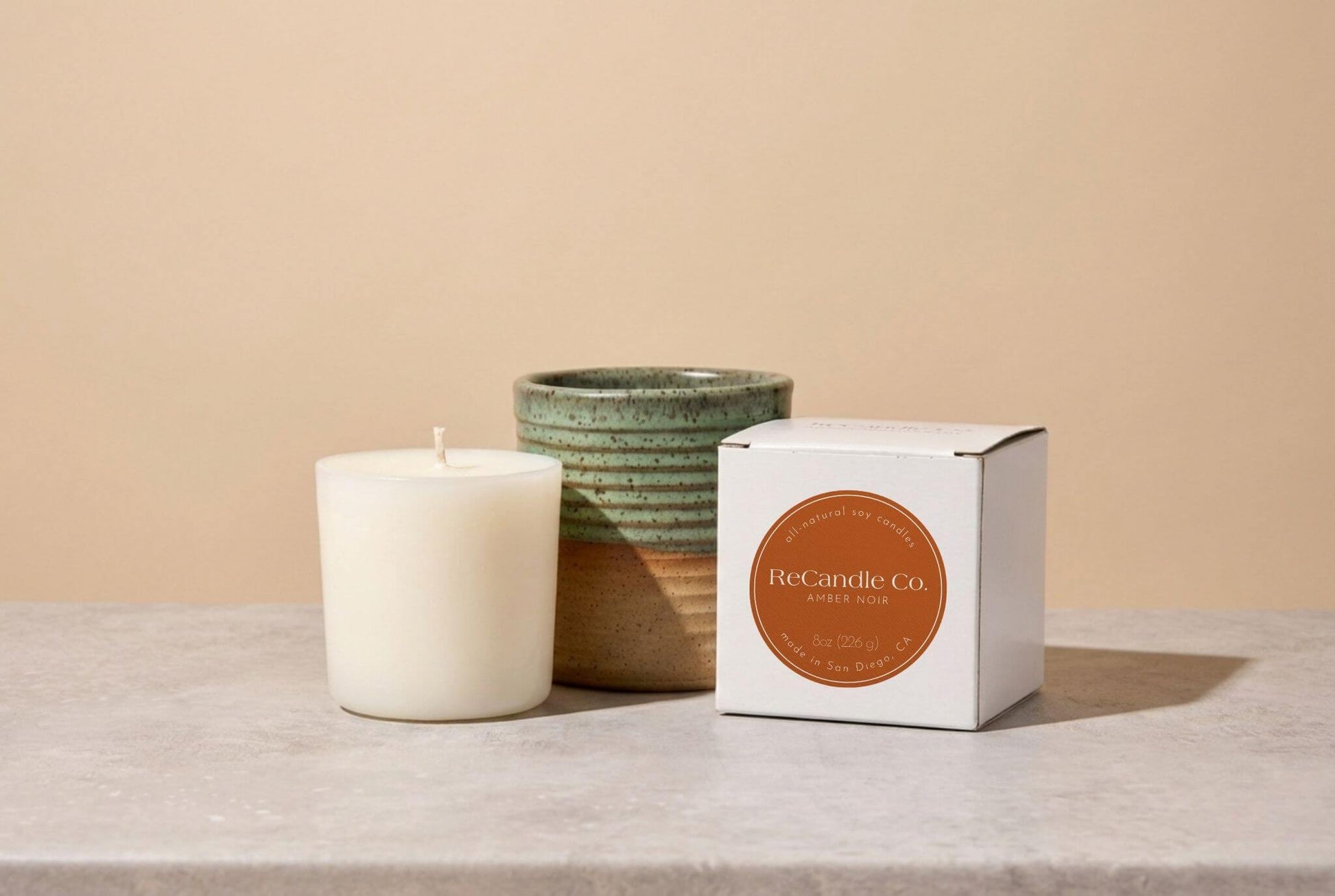 Refillable Amber Noir candle in handmade teal ceramic jar with natural soy refill