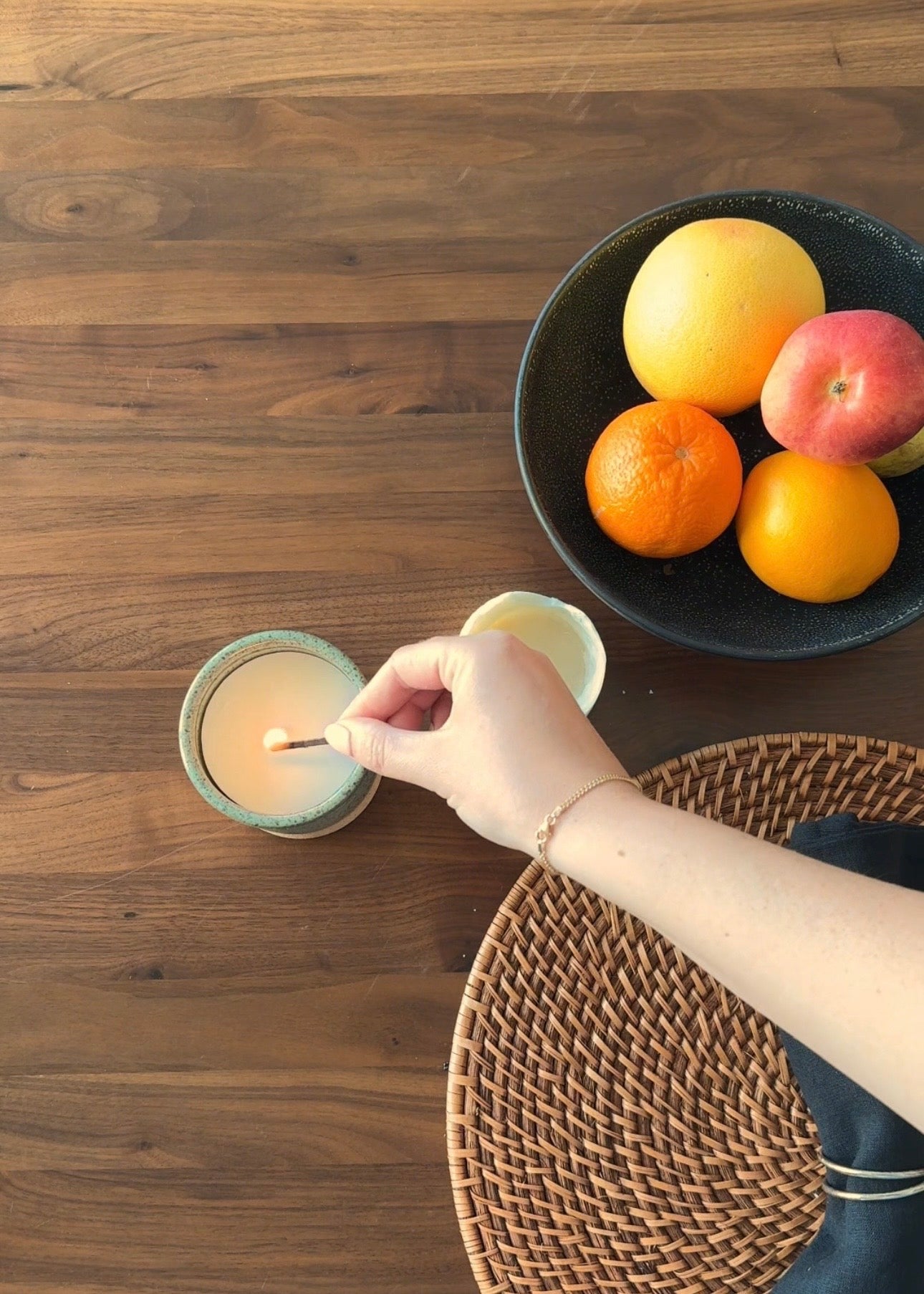 A hand lighting a refillable candle