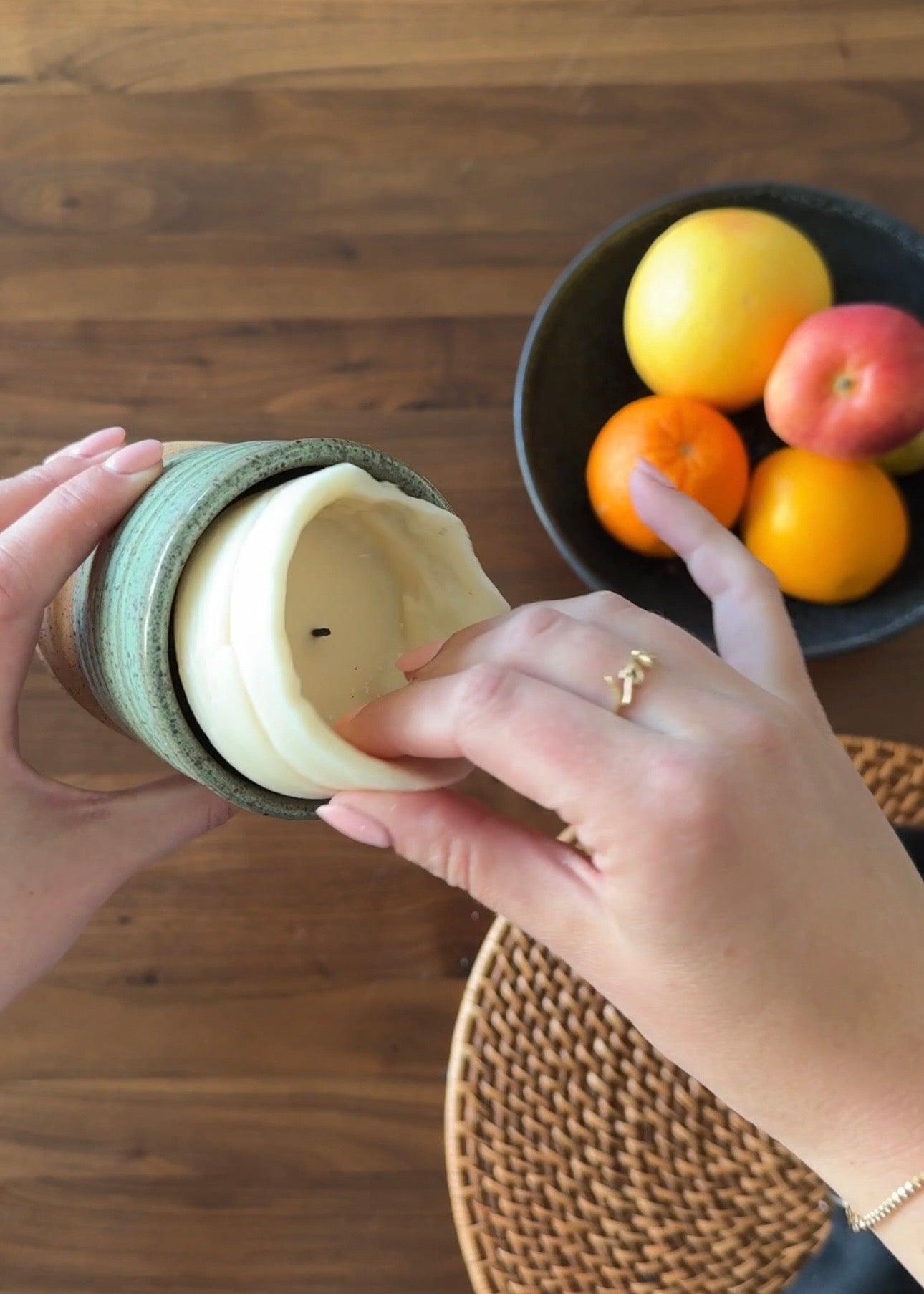 A hand pulling out a burned candle refill