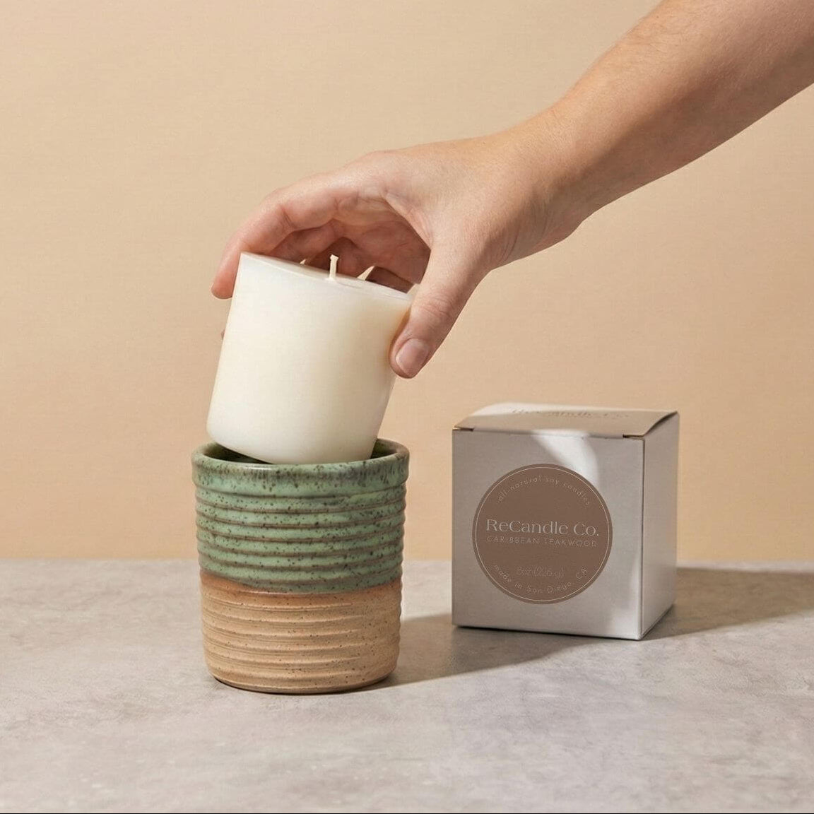 Inserting Caribbean Teakwood candle refill into sustainable teal ceramic refillable candle jar