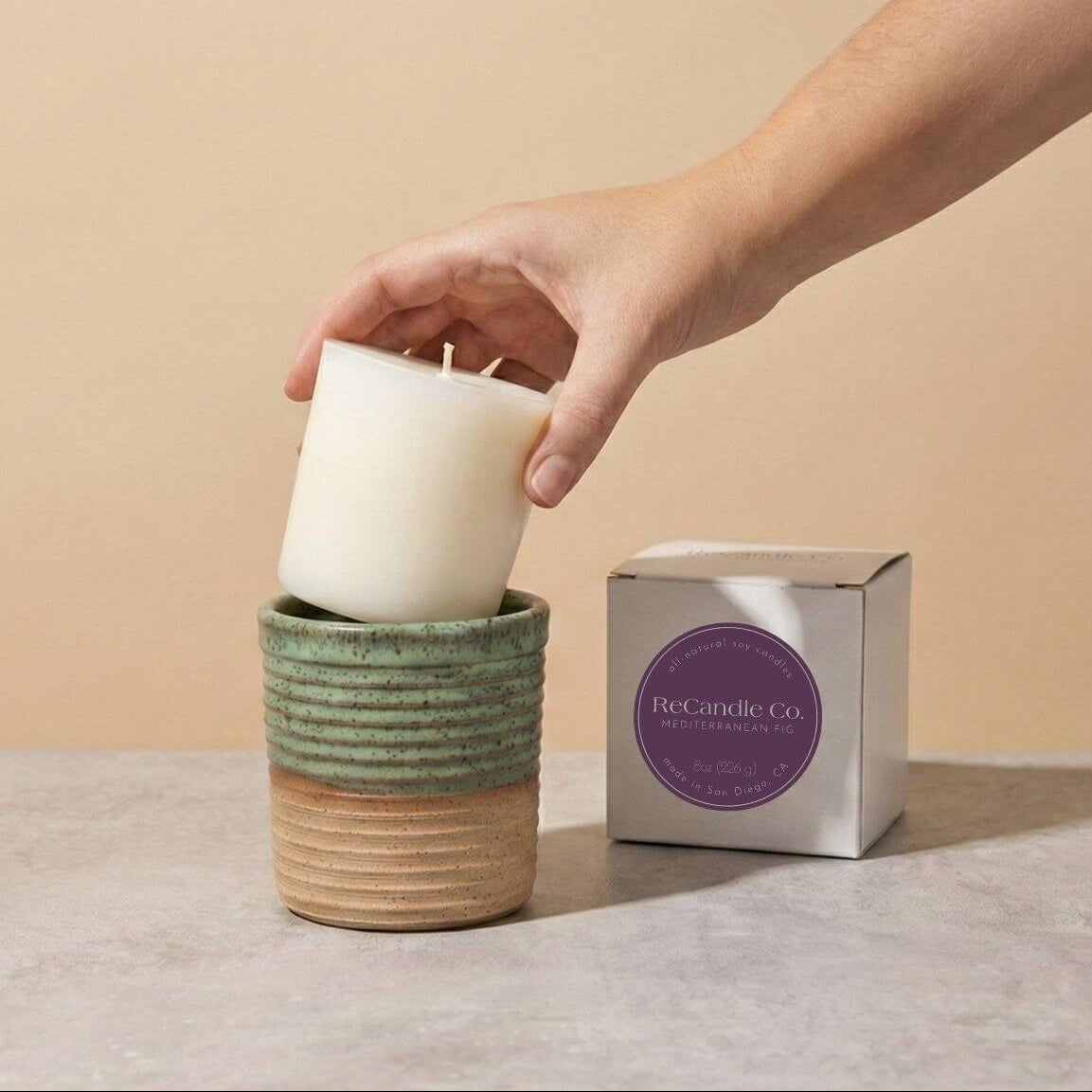 Inserting Mediterranean Fig candle refill into sustainable teal ceramic refillable candle jar