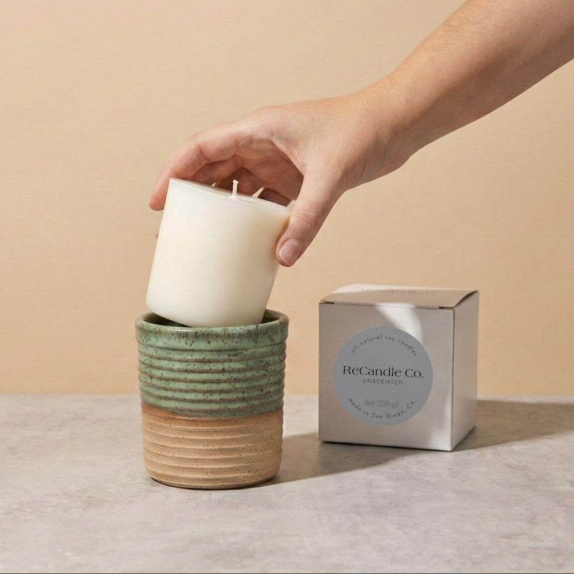 Inserting Unscented candle refill into sustainable teal ceramic refillable candle jar