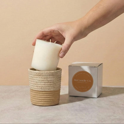 Person placing Pumpkin Chai soy candle refill into walnut ceramic refillable candle holder
